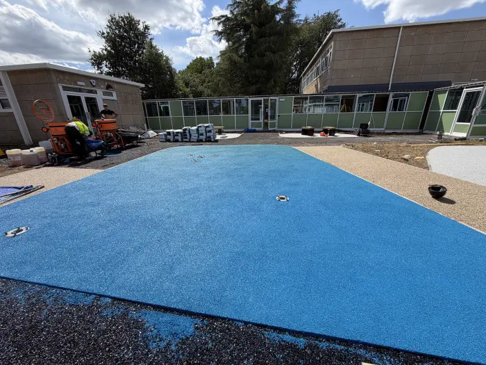 Blue rubber EPDM wet pour playground surfacing at a school, by A&P Resin