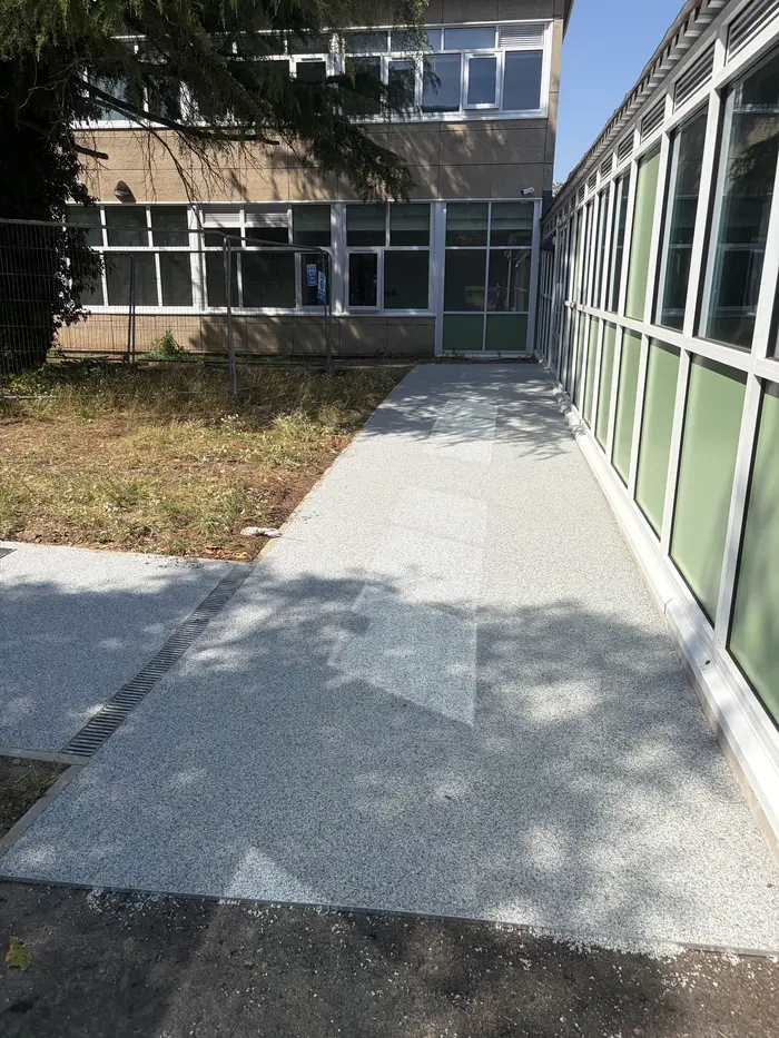 Grey resin bound walkway alongside a school building, by A&P Resin