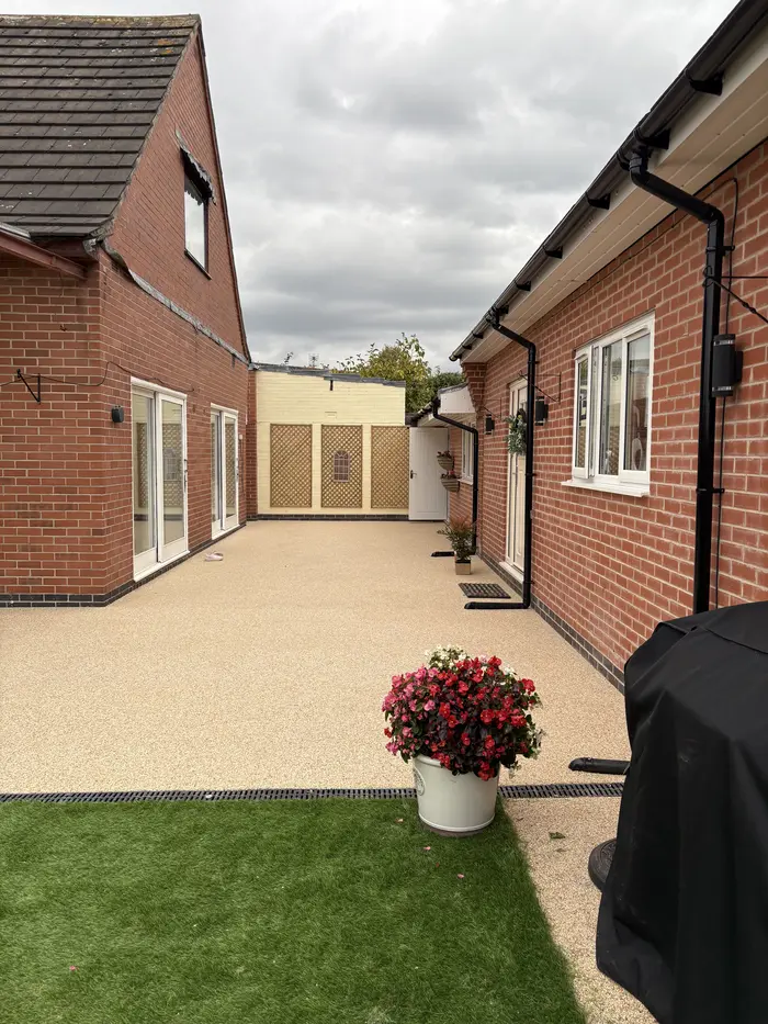 Cream resin bound patio with artificial grass and planters, by A&P Resin