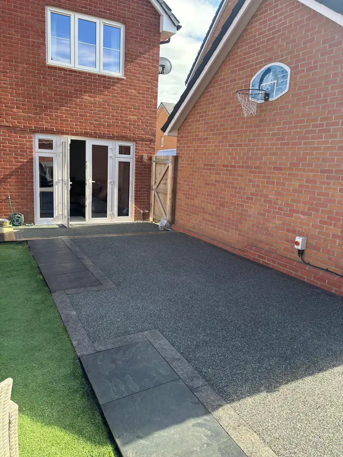 Grey resin bound patio at the back of a brick house, by A&P Resin